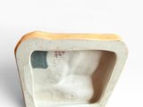 a small box with a cat in it on a white surface