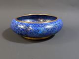 a blue and gold bowl sitting on a gray surface
