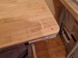 a wooden table with a sign on it in the corner of a room