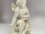 a small statue of a woman sitting on a stool