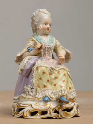a figurine of a woman sitting on a table