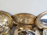 de nombreux plats et cuillères en argent posés sur une table