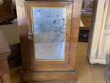 une petite armoire en bois surmontée d'un miroir