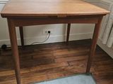 une petite table en bois avec un tiroir en dessous