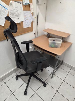 une chaise de bureau noire placée devant un bureau en bois