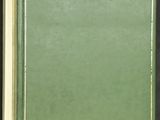 un livre ouvert, à la couverture verte, posé sur une table