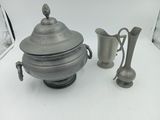 une théière en argent et un vase en argent posés sur une table