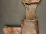 an old leather tool case with a knife in it on a gray surface