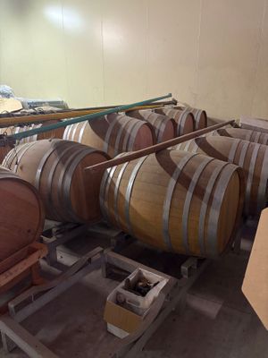 many barrels that are stacked on a cart in a room