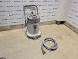un aspirateur posé sur le sol à côté d'un tuyau