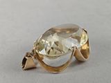a close up of a gold ring with a large faceted quartz stone