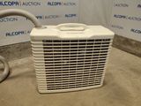 a white air conditioner sitting on the floor