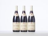 three bottles of red wine sitting on top of a table