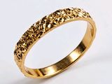 gros plan d'une bague en or sur fond blanc