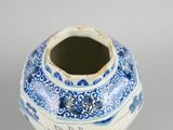 a blue and white vase that has a butterfly on it