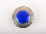 une image montrant un gros plan d'un bouton bleu sur une surface blanche