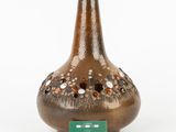 a brown vase with a green tag on it