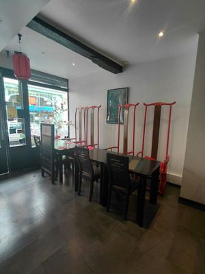 une table et des chaises dans une pièce avec une grande fenêtre