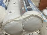 a pile of white pillows and blankets on a table