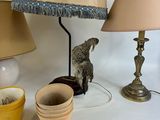 a table with a lamp, cups, and a lamp shade on it