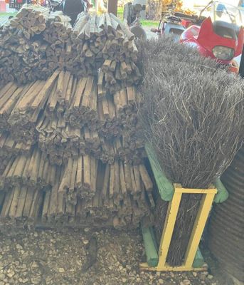 un tas de bois et un balai posés par terre