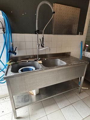 une cuisine équipée d'un évier et d'un lave-linge