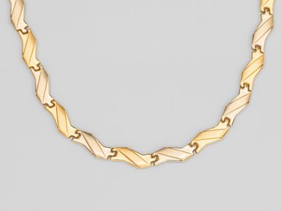 un collier à chaîne dorée au motif torsadé sur fond gris