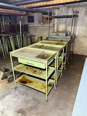 many tables and carts in a room with a lot of shelves