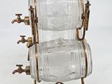 a glass bottle on a metal stand with two bottles on it