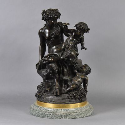 a bronze statue of a woman sitting on a rock with a dog