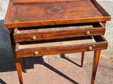 a small wooden table with two drawers on it