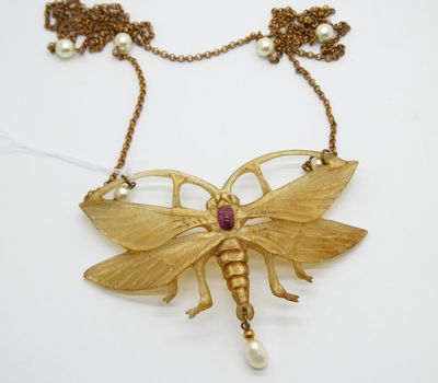 un gros plan d'un collier orné d'un papillon
