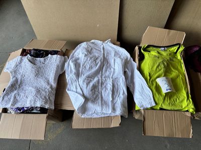 three boxes of clothing sitting on top of a floor next to each other