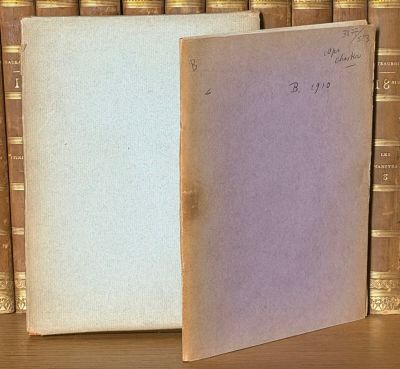 un vieux livre posé sur une table en bois, à côté d'une pile de livres