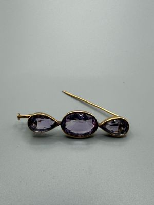 un gros plan sur une paire de boucles d'oreilles ornées de pierres violettes
