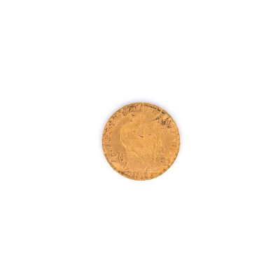 gros plan d'une pièce d'or sur une surface blanche