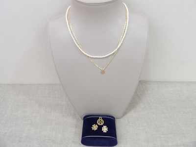 Ensemble collier et boucles d'oreilles de couleur dorée, présenté dans un étui en velours bleu