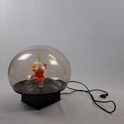 une boule de verre contenant un poisson, posée sur une table