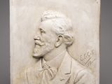 une plaque en marbre blanc sur laquelle figure l'image d'un homme en costume-cravate