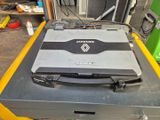 un ordinateur portable posé sur une boîte dans un garage