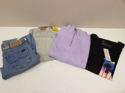 Trois paires de jeans et un t-shirt sont posés sur une table