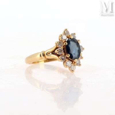 a close up of a gold ring with a blue sapphire and white diamonds