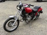 a red motorcycle parked in a parking lot next to other cars