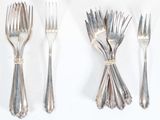 four forks and a knife on a white table