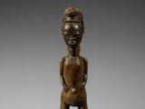 une statue en bois d'un homme avec un chapeau sur la tête