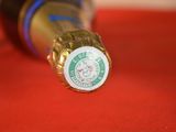a close up of a bottle of beer on a red cloth