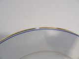 a white bowl with a gold rim on a white table