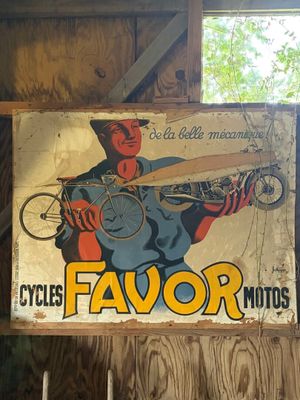une affiche sur laquelle on peut lire « Cycles Favor Moto » accrochée au mur
