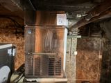 un petit réfrigérateur dans une chambre sale au sol sale
