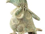 bronze figurine of a bird with a long beak and a long tail